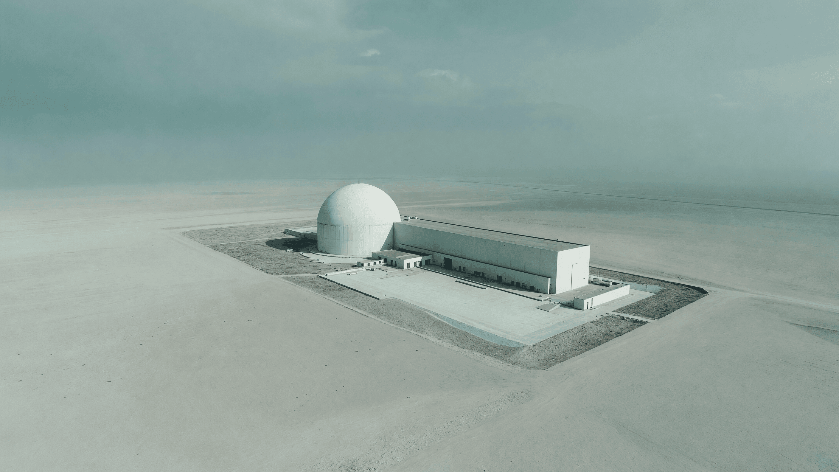 Aerial view of a containment dome and turbine hall — the NRC's AP1000 exemption decision leads today's brief. Illustration: NNN