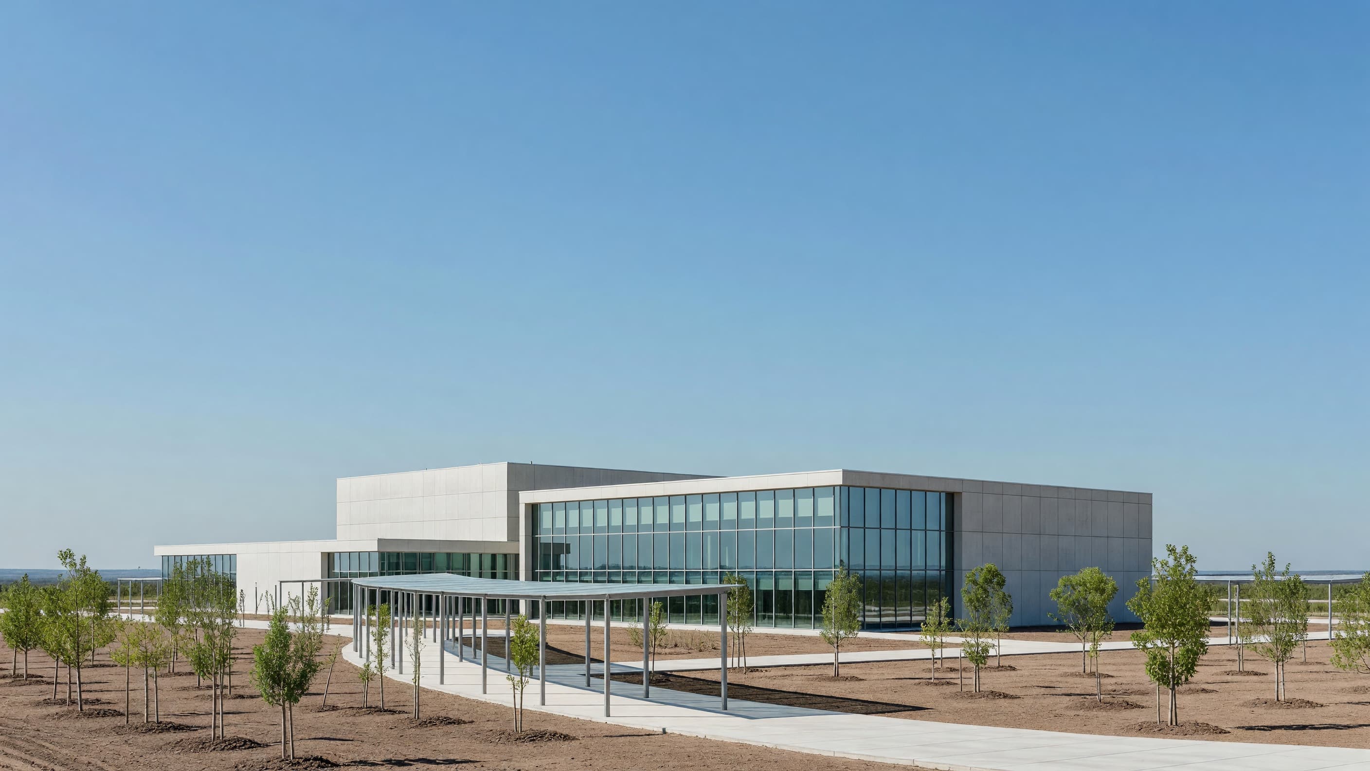 A modern concrete-and-glass nuclear lifecycle innovation research campus under a clear blue sky, representing the five states named as DOE Lifecycle Innovation Campus finalists. Illustration: NNN