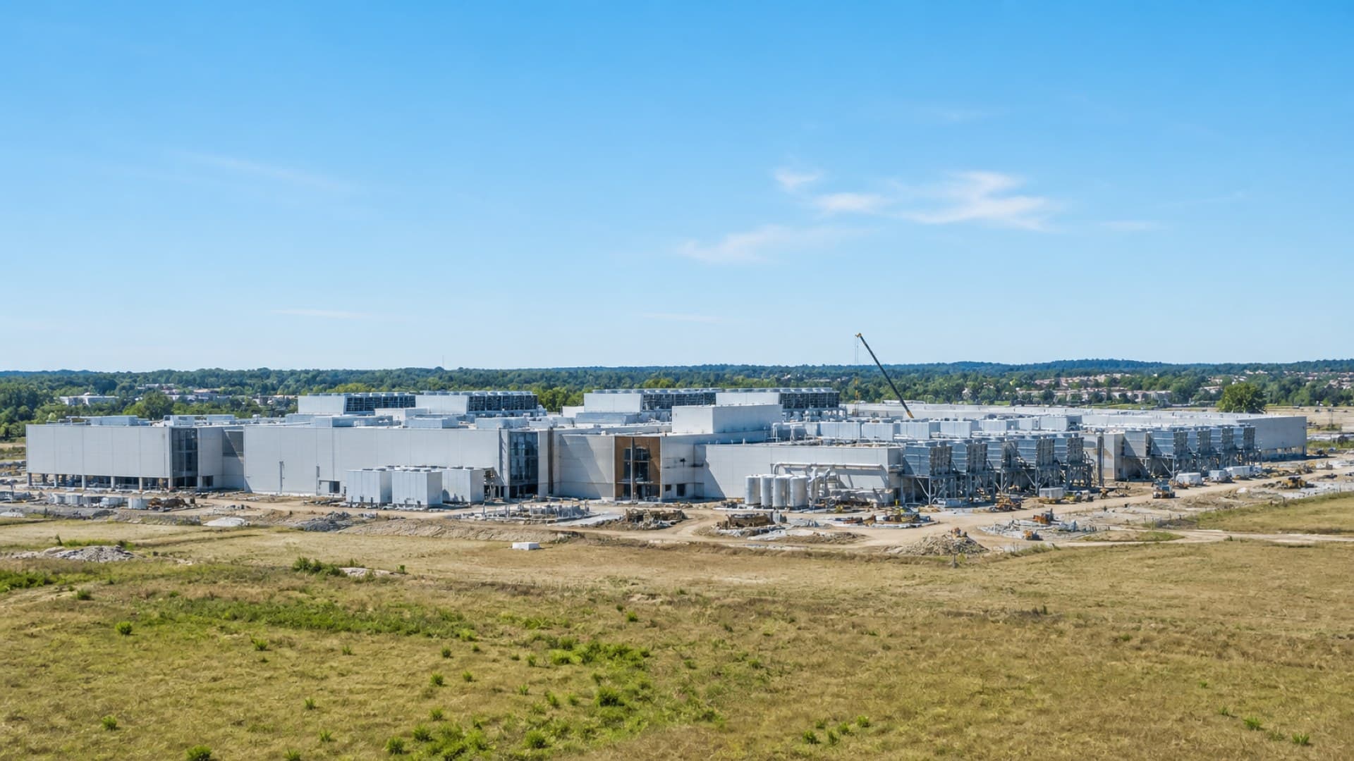 An AI data center campus under construction near an American town, illustrating Gallup's finding that local opposition to data centers exceeds opposition to nuclear plants. Illustration: NNN