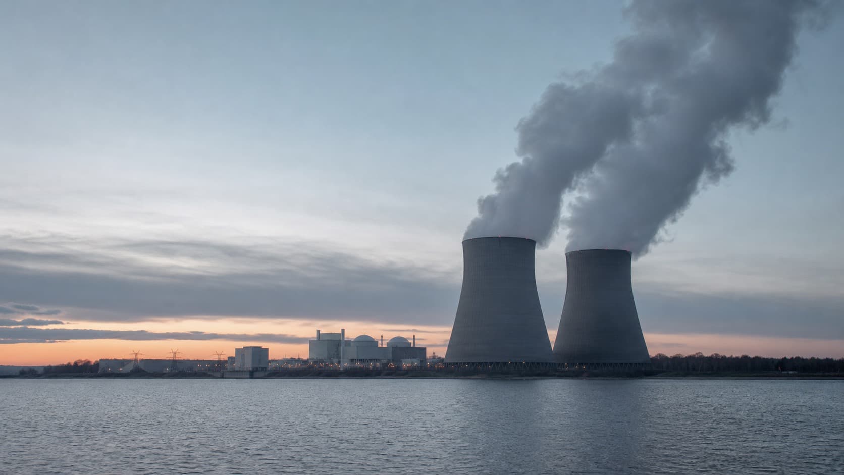 A nuclear power station with natural-draught cooling towers at dusk, representing nuclear's baseload role versus natural gas. Illustration: NNN.