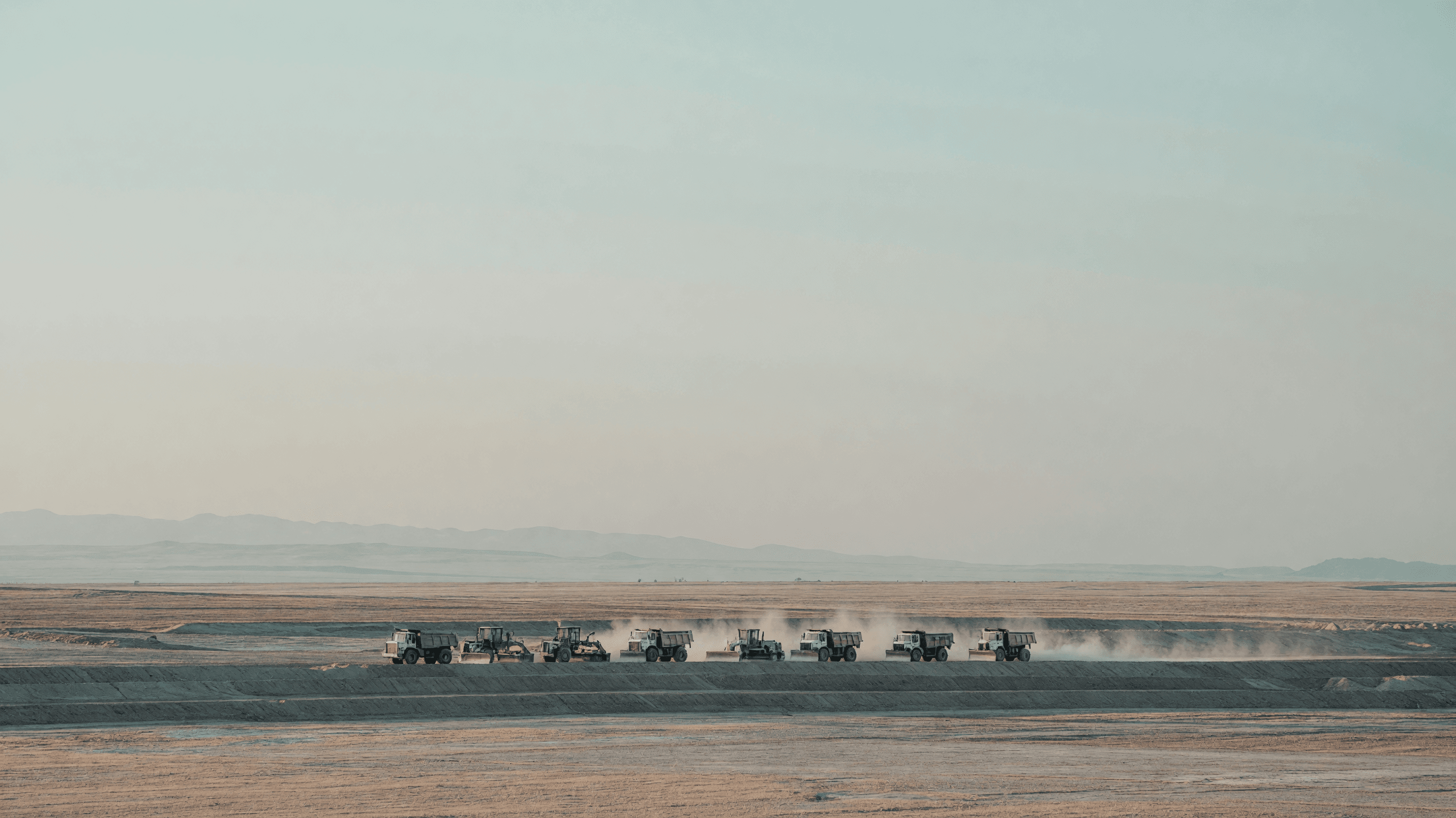 Earthmovers work a terraced cut on the Wyoming high plains — TerraPower's Kemmerer excavation leads today's brief. Illustration: NNN