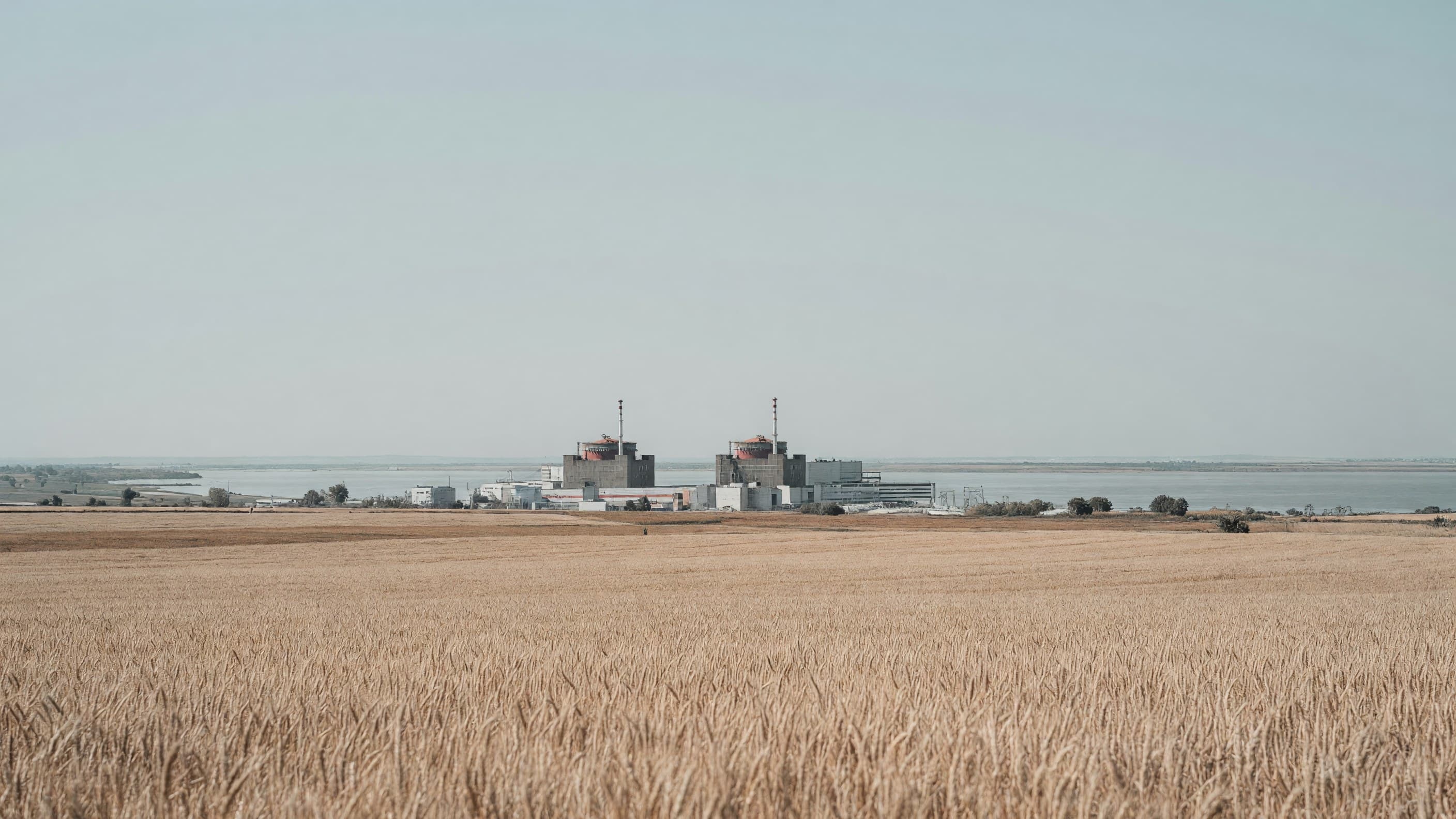 The two operating VVER-1000 units at Kozloduy seen across the Danube plain — Bulgaria's AP1000 new-build commitment leads today's brief. Illustration: NNN