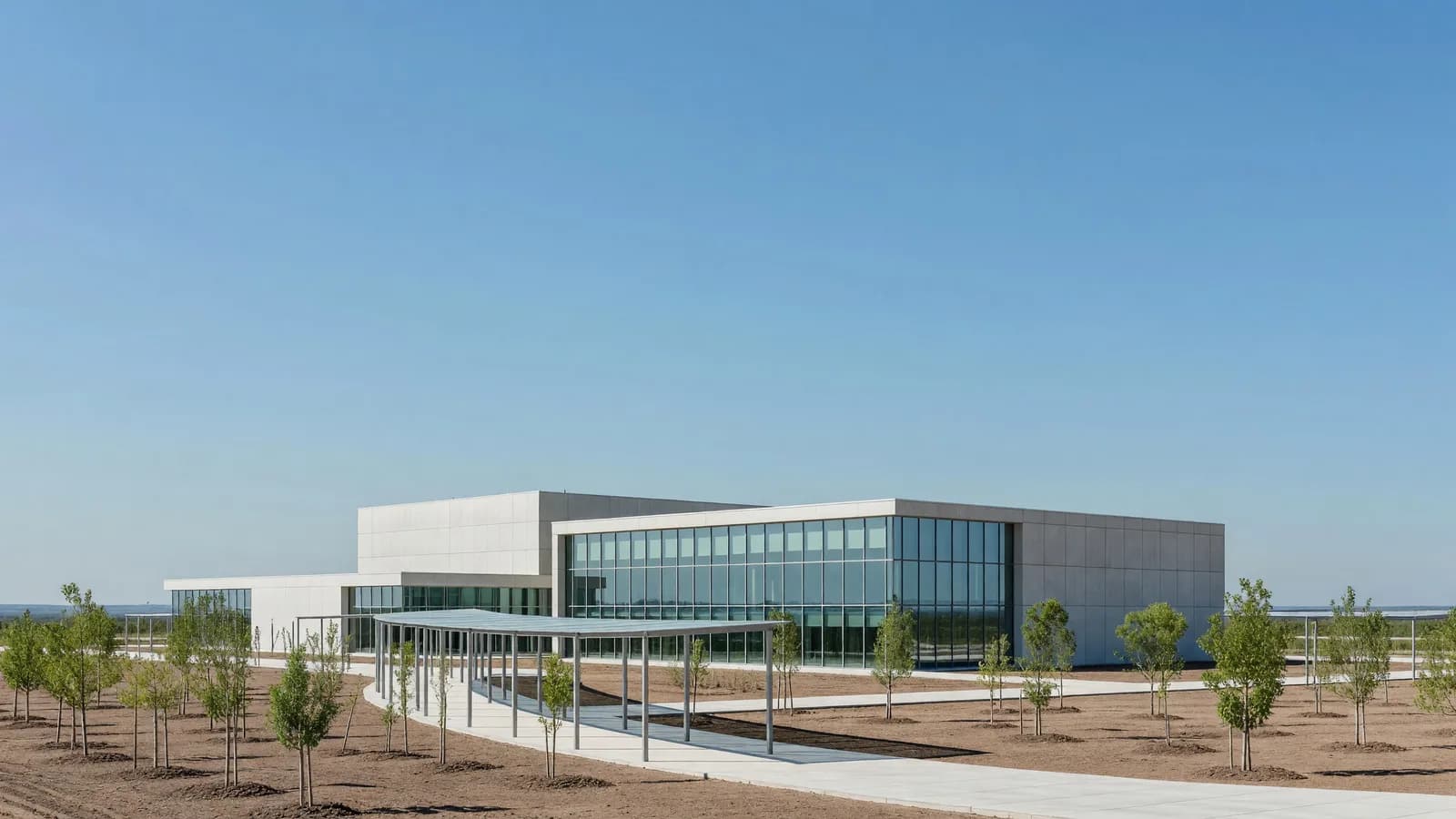 A modern concrete-and-glass nuclear lifecycle innovation research campus under a clear blue sky, representing the five states named as DOE Lifecycle Innovation Campus finalists. Illustration: NNN