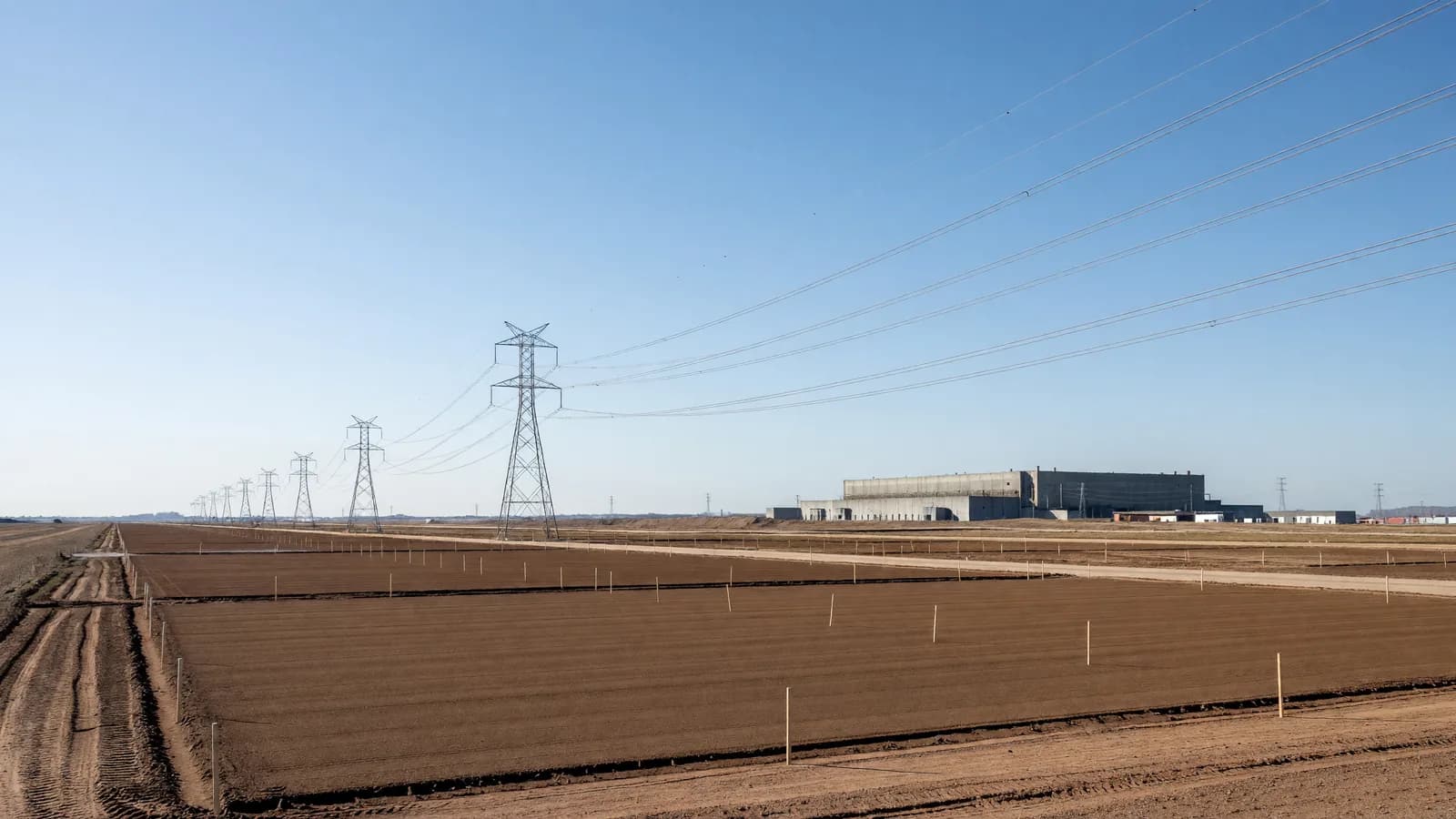 A cleared and graded construction parcel crossed by high-voltage lines beside the former Paducah Gaseous Diffusion Plant in Kentucky, where General Matter seeks an NRC license for its enrichment facility. Illustration: NNN