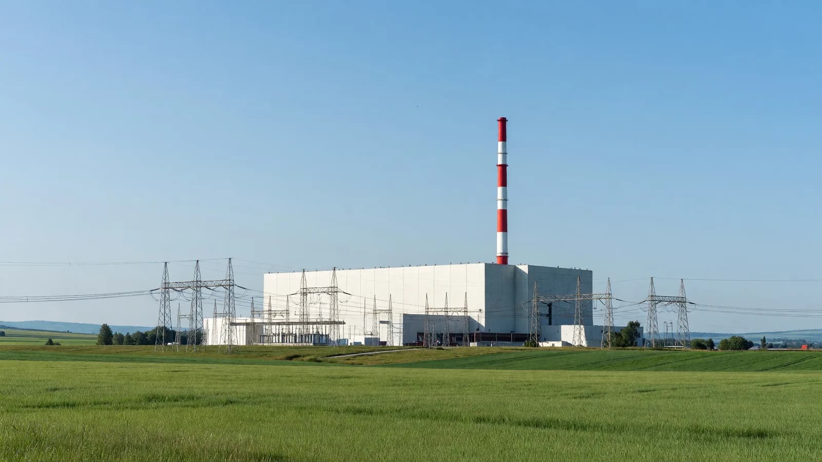 The Mochovce nuclear power plant in Slovakia with transmission lines in the foreground, as Mochovce 4 begins feeding electricity to the grid. Illustration: NNN