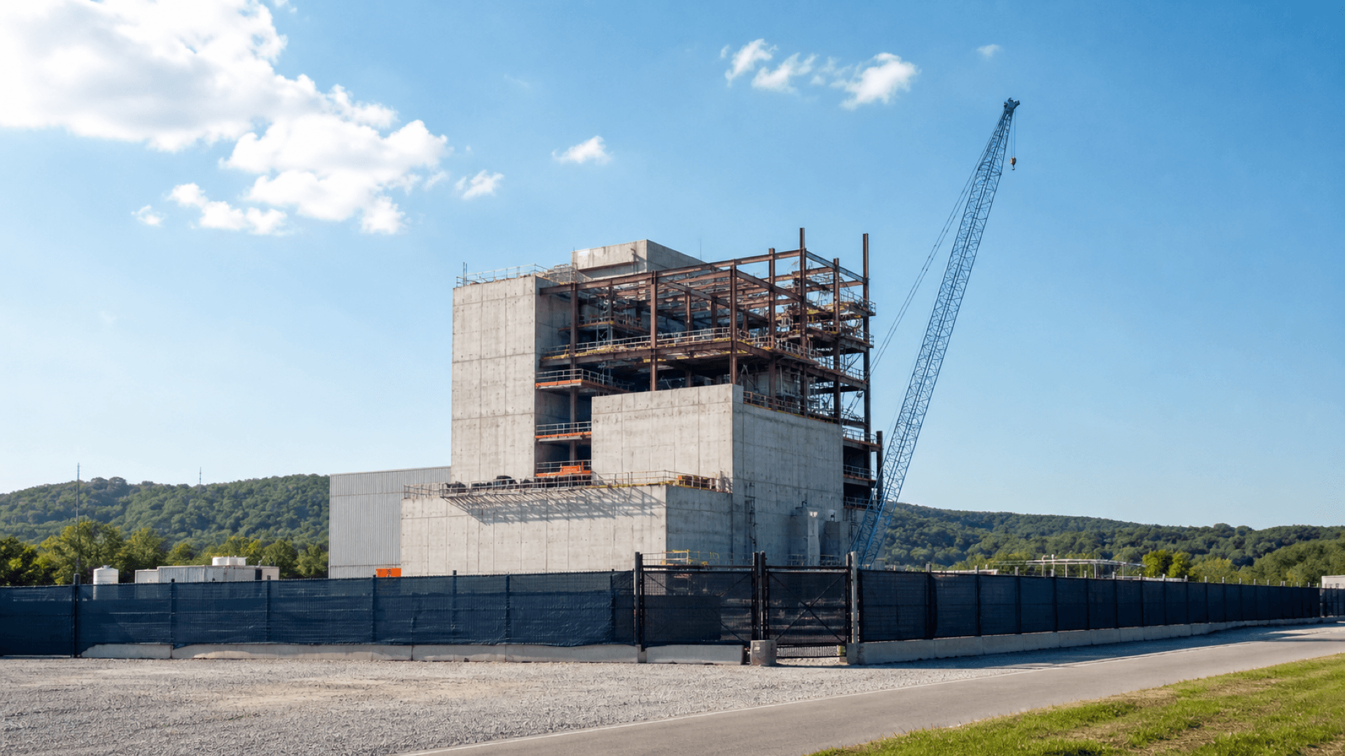 A reactor demonstration plant rises at a construction site in Oak Ridge, Tennessee, illustrating Nature's report on smaller reactors and AI-era electricity demand. Illustration: NNN