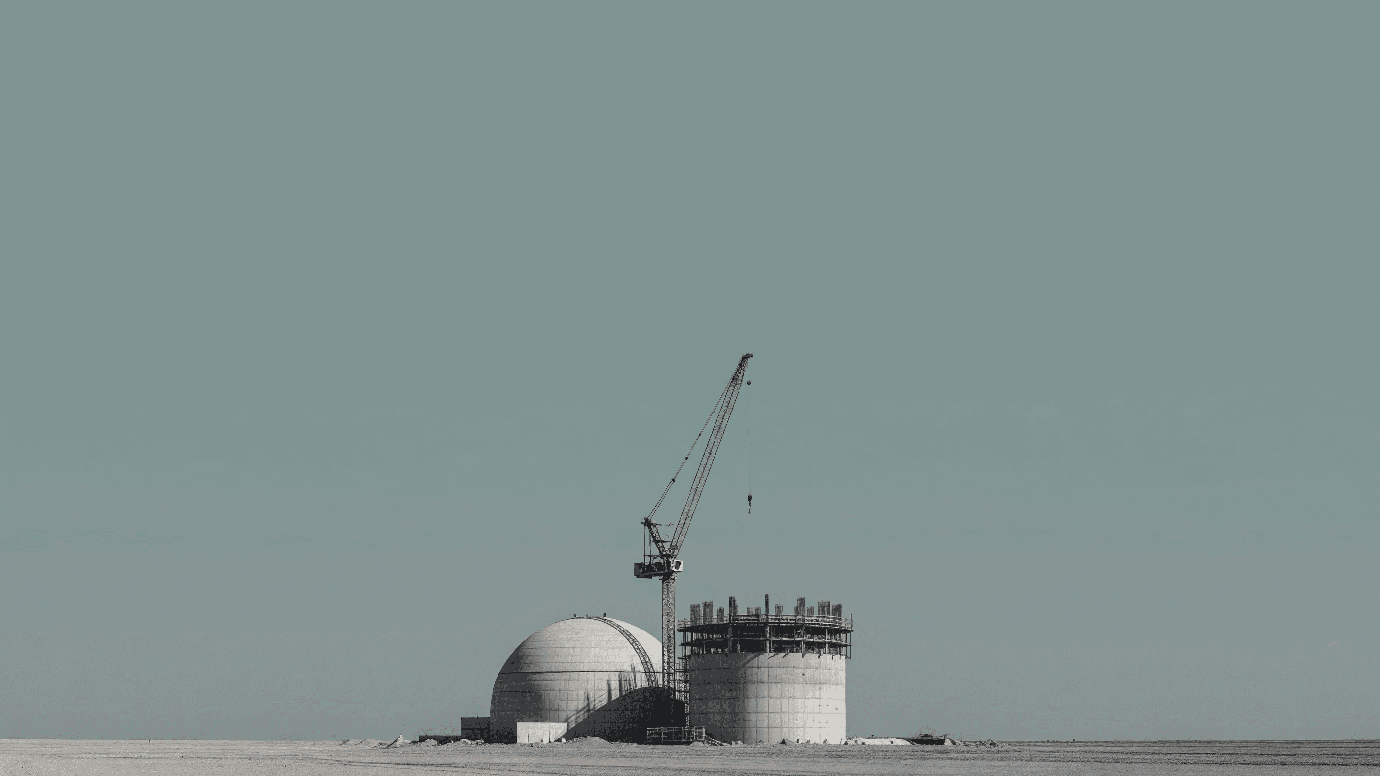 An AP1000-style containment and shield building under construction beside a tower crane. Illustration: NNN