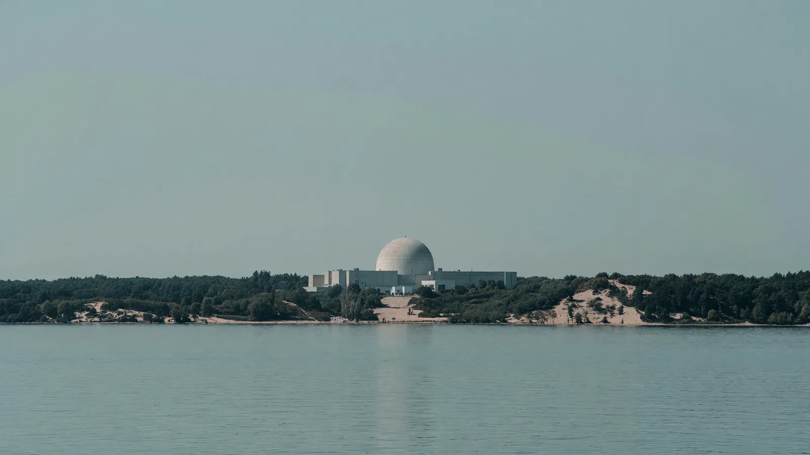 The Palisades dome on Lake Michigan's wooded dune shoreline — the site where Holtec plans its two SMR-300 Pioneer units. Illustration: NNN